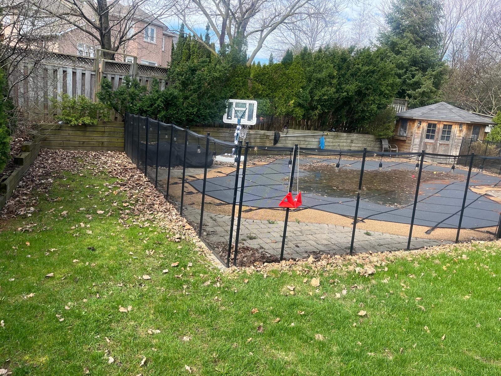 Freshly maintained backyard lawn beside a basketball court